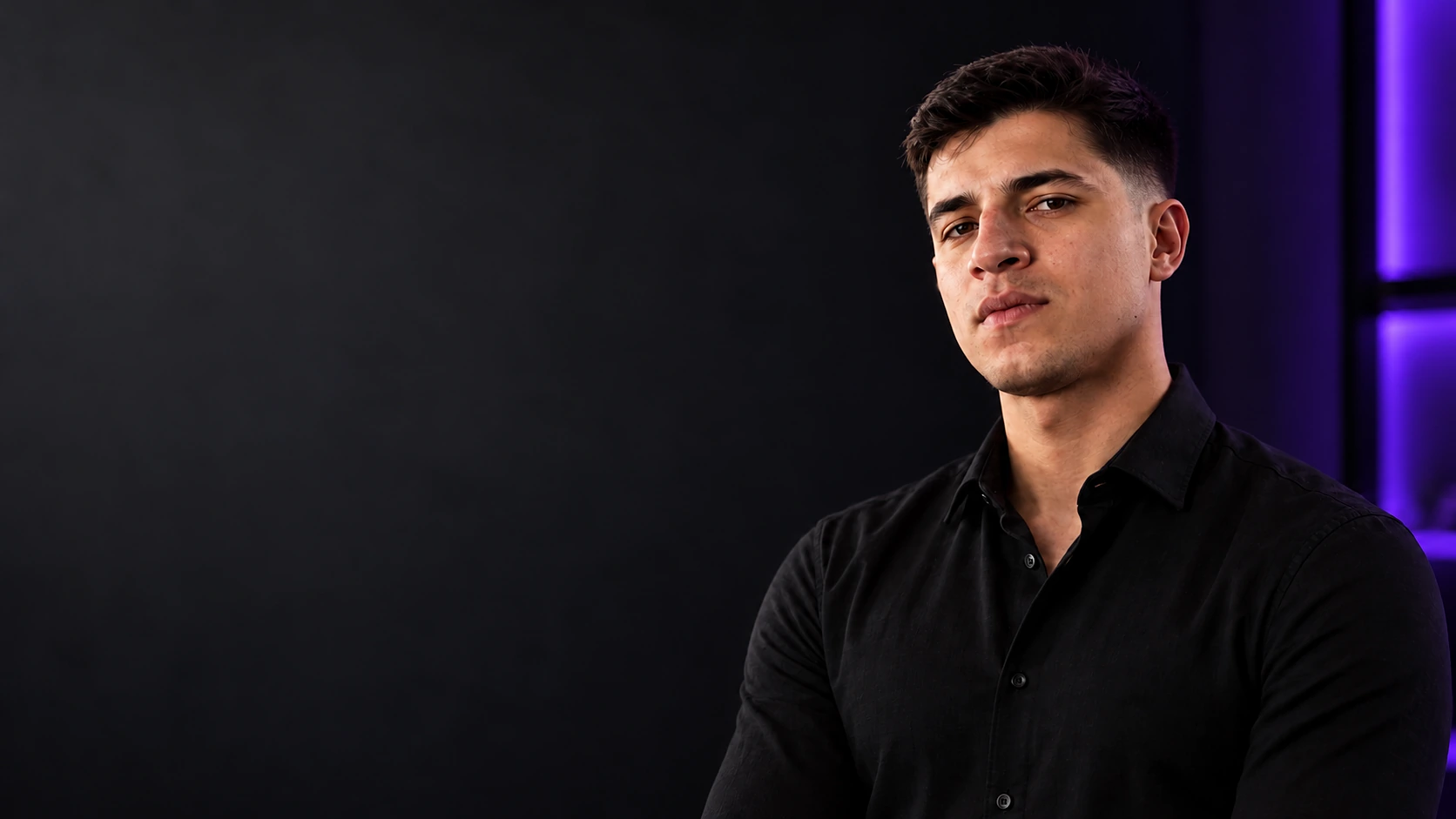 Micael Dimitri, de camisa preta, em fundo escuro